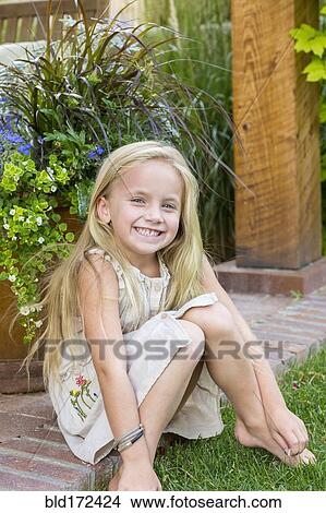 Picture - Caucasian girl sitting in backyard. Fotosearch