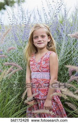 Stock Photograph - Caucasian girl smiling in tall grass. Fotosearch