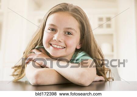 Stock Photo - Caucasian girl smiling on table. Fotosearch