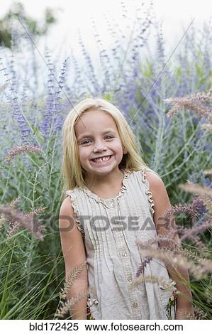 Caucasian girl standing in tall flowers View Large Photo Image Stock Photography - Caucasian girl standing in tall flowers. Fotosearch