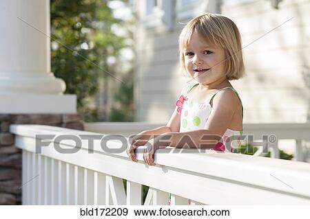 Stock Photo - Caucasian girl standing on patio. Fotosearch
