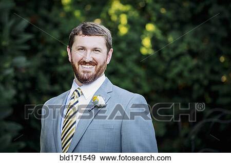 Stock Photo - Caucasian groom smiling in garden. Fotosearch