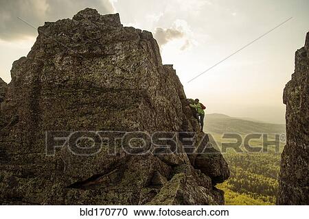 Caucasian hiker climbing on rock formation View Large Photo Image Stock Image - Caucasian hiker climbing on rock formation. Fotosearch