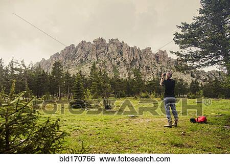 Caucasian hiker photographing mountain in remote landscape View Large Photo Image Stock Photograph - Caucasian hiker photographing mountain in remote landscape. Fotosearch