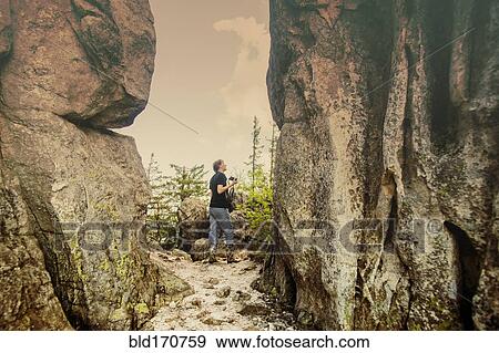Caucasian hiker walking by remote cliffs View Large Photo Image Stock Photo - Caucasian hiker walking by remote cliffs. Fotosearch