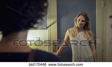 Stock Photo - Caucasian lesbian couple standing in hallway. Fotosearch