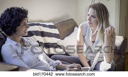 Caucasian lesbian couple talking on sofa View Large Photo Image Stock Image - Caucasian lesbian couple talking on sofa. Fotosearch
