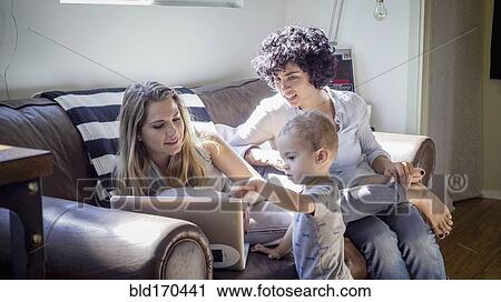 Caucasian lesbian mothers and baby son on sofa View Large Photo Image Stock Image - Caucasian lesbian mothers and baby son on sofa. Fotosearch