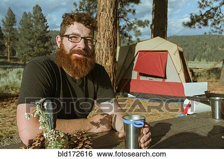 Caucasian man drinking at campsite View Large Photo Image Stock Photograph - Caucasian man drinking at campsite. Fotosearch