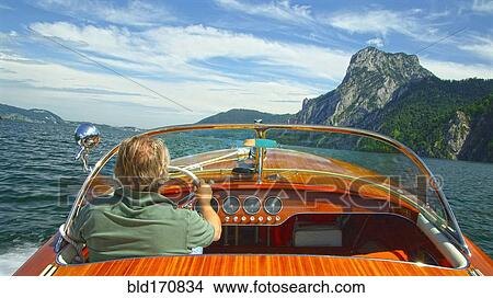 Caucasian man driving speedboat on remote lake View Large Photo Image Picture - Caucasian man driving speedboat on remote lake. Fotosearch