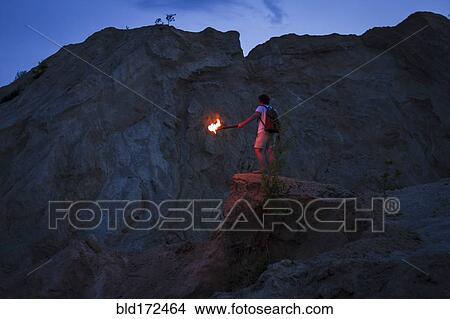 Caucasian man holding torch under rocky cliff View Large Photo Image Picture - Caucasian man holding torch under rocky cliff. Fotosearch