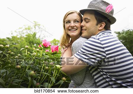 Caucasian man hugging girlfriend in garden View Large Photo Image Picture - Caucasian man hugging girlfriend in garden. Fotosearch