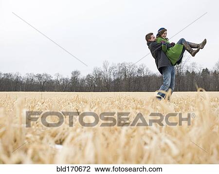 Caucasian man lifting girlfriend in rural field View Large Photo Image Stock Image - Caucasian man lifting girlfriend in rural field. Fotosearch