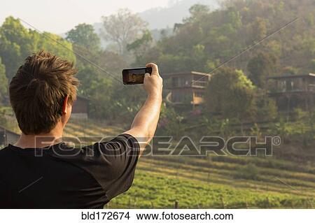 Caucasian man photographing rural fields View Large Photo Image Picture - Caucasian man photographing rural fields. Fotosearch