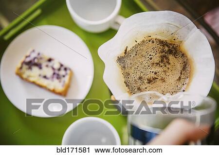 Stock Image - Caucasian man pouring breakfast coffee. Fotosearch