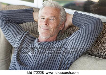 Caucasian man relaxing on sofa View Large Photo Image Stock Photo - Caucasian man relaxing on sofa. Fotosearch