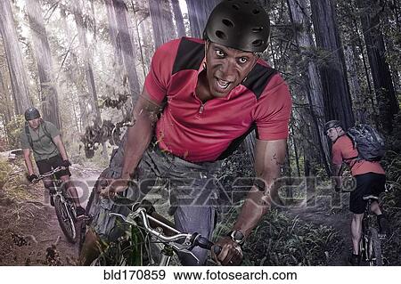 Stock Photo - Caucasian man riding mountain bike in forest. Fotosearch