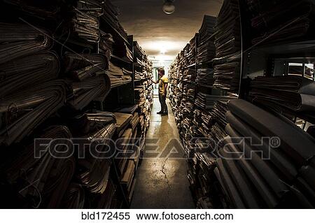 Caucasian man searching old newspapers in library archive View Large Photo Image Stock Photography - Caucasian man searching old newspapers in library archive. Fotosearch