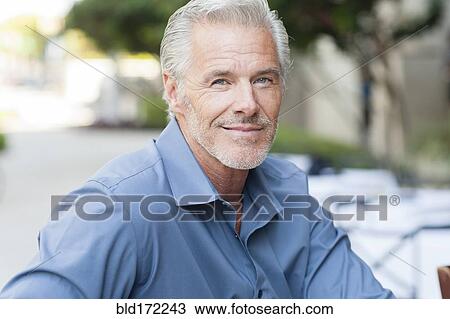 Stock Image - Caucasian man sitting in city. Fotosearch
