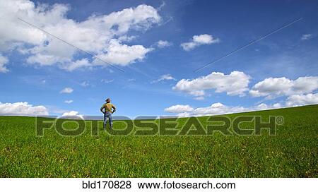 Stock Photo - Caucasian man standing in rural field. Fotosearch