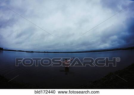 Caucasian man standing in still remote lake View Large Photo Image Stock Image - Caucasian man standing in still remote lake. Fotosearch