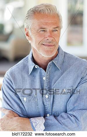 Stock Image - Caucasian man standing with arms crossed. Fotosearch
