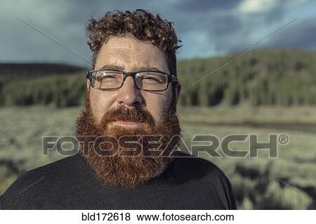Caucasian man with beard standing in remote field View Large Photo Image Stock Photo - Caucasian man with beard standing in remote field. Fotosearch