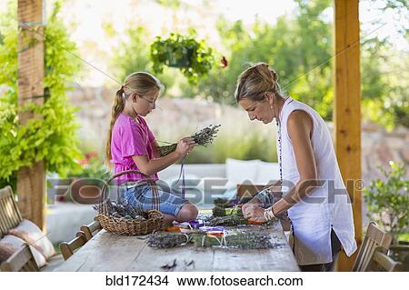 Picture - Caucasian mother and daughter making dried flower bundles. Fotosearch