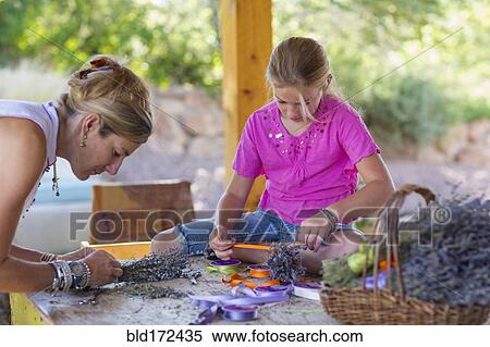 Stock Photography - Caucasian mother and daughter making dried flower bundles. Fotosearch