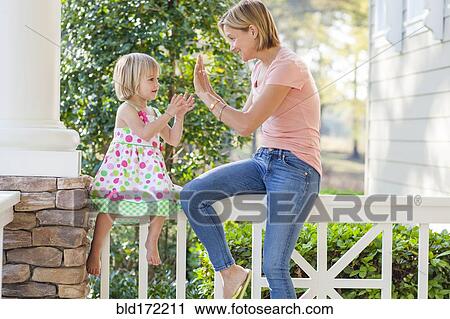 Caucasian mother and daughter playing on patio View Large Photo Image Stock Image - Caucasian mother and daughter playing on patio. Fotosearch