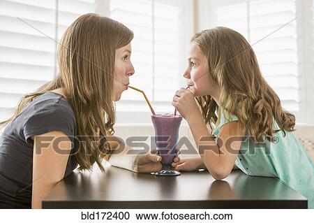 Caucasian mother and daughter sharing milkshake View Large Photo Image Stock Image - Caucasian mother and daughter sharing milkshake. Fotosearch