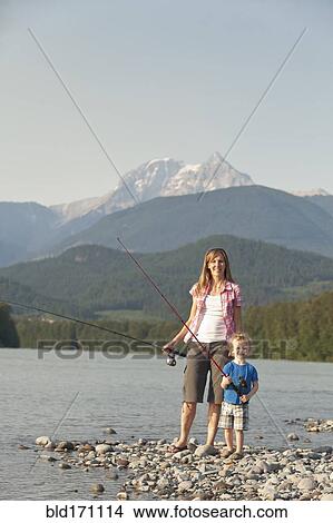 Picture - Caucasian mother and son fishing in remote lake. Fotosearch