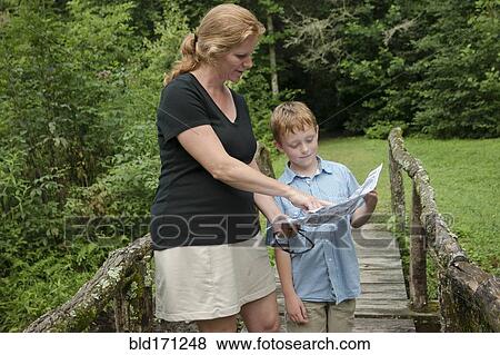 Caucasian mother and son reading map on footbridge in forest View Large Photo Image Stock Photo - Caucasian mother and son reading map on footbridge in forest. Fotosearch