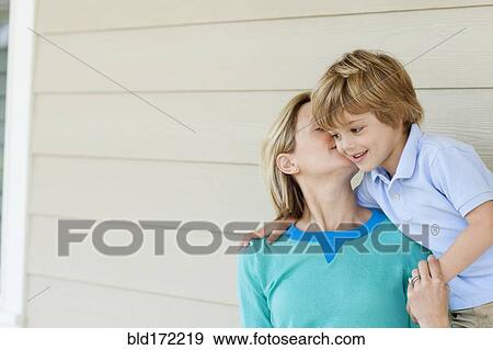 Caucasian mother kissing son on patio View Large Photo Image Stock Photo - Caucasian mother kissing son on patio. Fotosearch