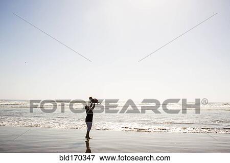 Caucasian mother lifting baby daughter on beach View Large Photo Image Stock Photo - Caucasian mother lifting baby daughter on beach. Fotosearch
