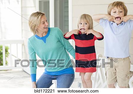 Caucasian mother watching children making faces on patio View Large Photo Image Stock Image - Caucasian mother watching children making faces on patio. Fotosearch