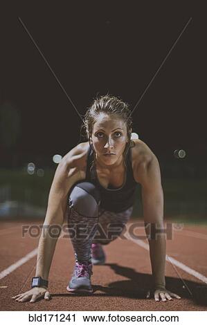 Caucasian runner in starting position on sports field View Large Photo Image Stock Image - Caucasian runner in starting position on sports field. Fotosearch