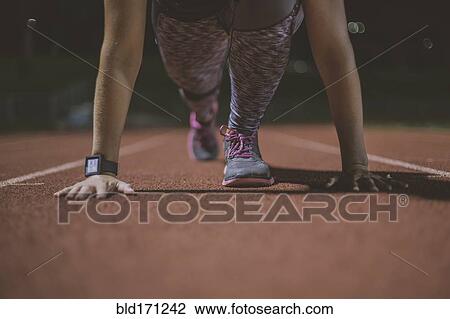 Caucasian runner in starting position on sports field View Large Photo Image Stock Image - Caucasian runner in starting position on sports field. Fotosearch