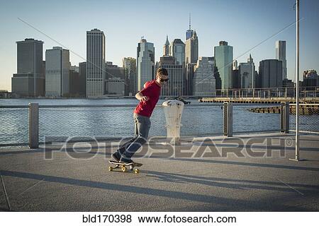 Caucasian skateboarder doing trick at waterfront, New York, United States View Large Photo Image Stock Photo - Caucasian skateboarder doing trick at waterfront, New York, United States. Fotosearch