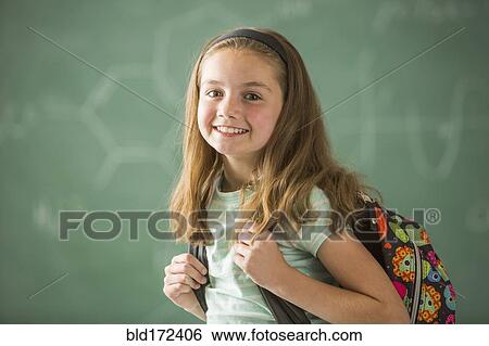 Stock Photograph - Caucasian student wearing backpack in classroom. Fotosearch