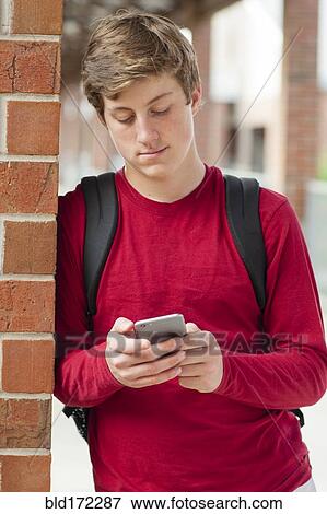 Stock Photo - Caucasian teenage boy using cell phone. Fotosearch