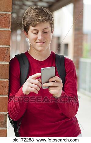 Caucasian teenage boy using cell phone View Large Photo Image Stock Photo - Caucasian teenage boy using cell phone. Fotosearch