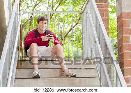 Caucasian teenage boy using cell phone on steps View Large Photo Image Stock Photography - Caucasian teenage boy using cell phone on steps. Fotosearch