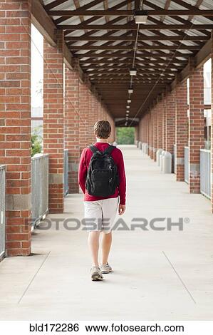 Stock Photograph - Caucasian teenage boy walking on school campus. Fotosearch