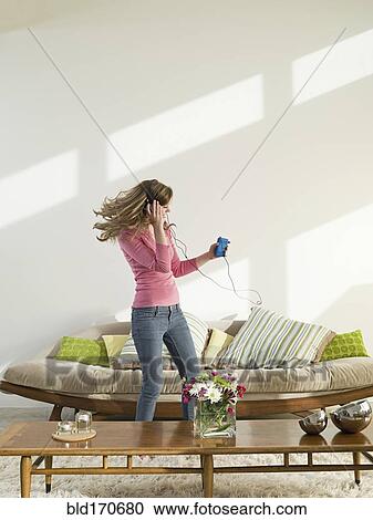Caucasian woman dancing to headphones in living room View Large Photo Image Stock Image - Caucasian woman dancing to headphones in living room. Fotosearch