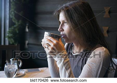 Caucasian woman drinking coffee in cafe View Large Photo Image Stock Photograph - Caucasian woman drinking coffee in cafe. Fotosearch