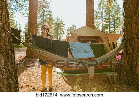 Picture - Caucasian woman hanging laundry at campsite. Fotosearch