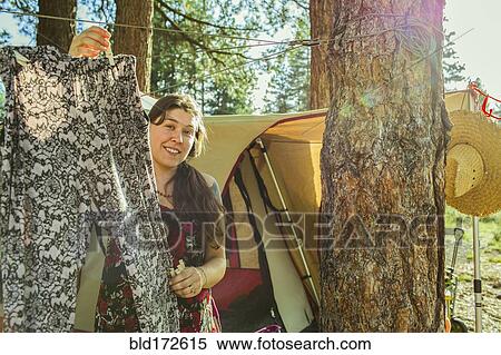Stock Photography - Caucasian woman hanging laundry at campsite. Fotosearch
