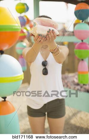 Stock Photo - Caucasian woman holding conch shell. Fotosearch