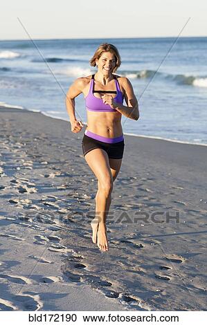 Caucasian woman jogging on beach View Large Photo Image Stock Image - Caucasian woman jogging on beach. Fotosearch